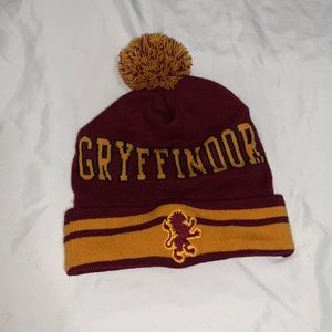 a burgundy and gold beanie with a pom-pom